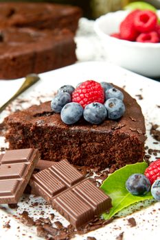 chocolate cake with fresh berry on white dish and black background