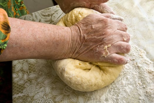 Hands of old woman making dough