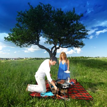 man and woman on picnic in green grass