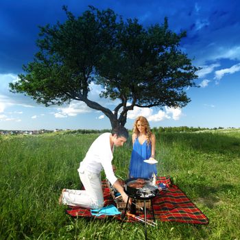 man and woman on picnic in green grass