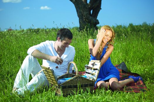 man and woman on picnic in green grass