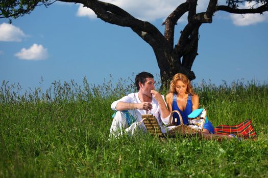 man and woman on picnic in green grass