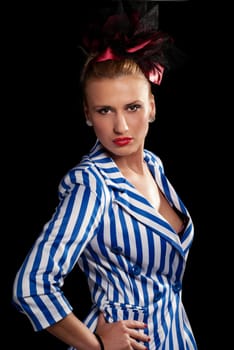 Provocative look on a young woman in striped jacked isolated on black