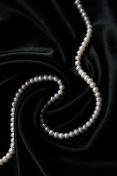 White pearls on the black velvet background 