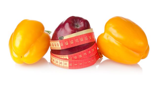 Vegetarian diet to lose weight with apple, two sweet pappers and measuring tape with soft shadews on white background