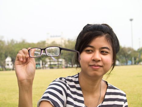 girl trying her glasses and checking out their dirtiness 