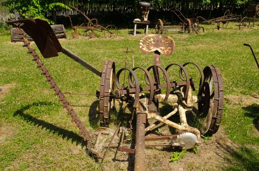 Vintage rusty grass cutting and harvesting agricultural machinery equipment.