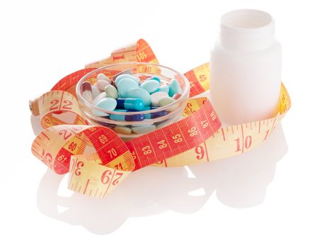 Different pills with white bottle and measurint tape with soft shadow on white background