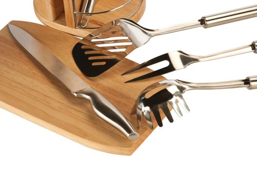 Silver kitchen utensils including whisk, tong and spoon on a white background and knife set