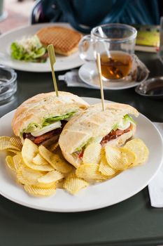 Clubsandwich with chips on a table setting