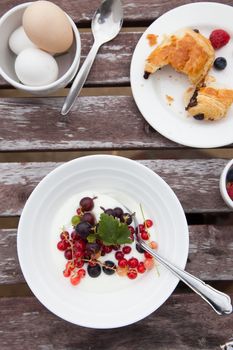 Breakfast table with yogurt, berries and eggs