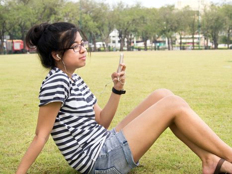 A young girl with headphones outdoors. Listening music 