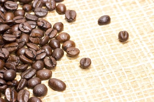 Fresh roasted coffee beans on light textured surface