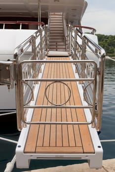 Chrome boarding walkway onto a luxury white yacht