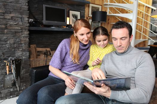 Parents reading a story to their daughter