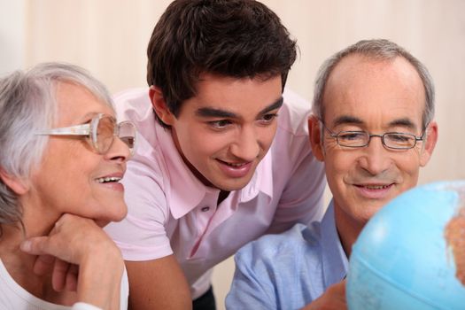 Parents and son looking at globe