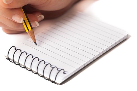 A woman's hand writing on a notepad with a pencil, isolated on a white background.
