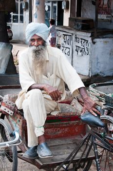 Amritsar, India - August 26, 2011: Rickshaw is a traditional asian taxi. Senior rickshaw is sitting on his cycle