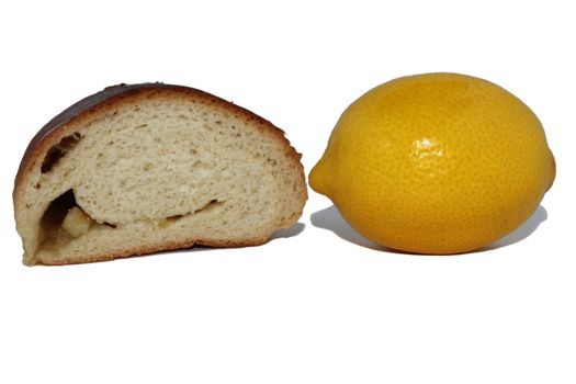 The roll cut half-and-half with a lemon and a lemon on a white background