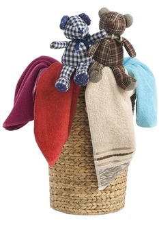 colorful towels in a basket isolated on white background and a resting teddy bears