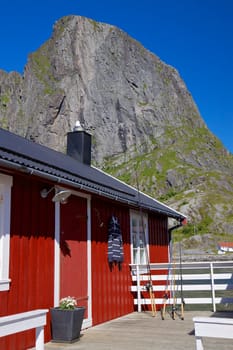 Typical red rorbu fishing hut by the fjord on Lofoten islands in Norway