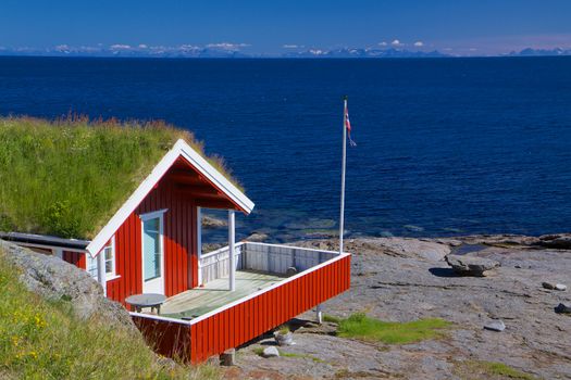 Typical red holiday hut with sod roof on Lofoten islands in Norway