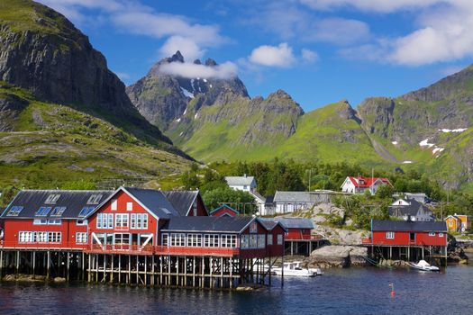 Picturesque village on Lofoten islands in Norway surrounded by high peaks of mountains