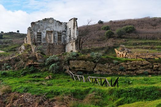 Farmhouse ruin among rural landscape