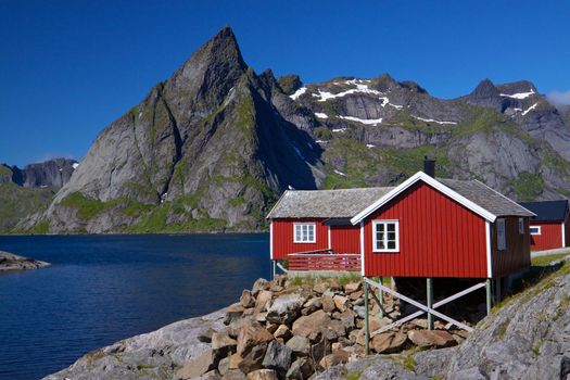 Typical red rorbu fishing hut by the fjord on Lofoten islands in Norway