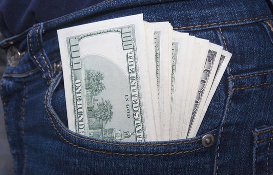 Bundle of dollars in a jeans rear pocket