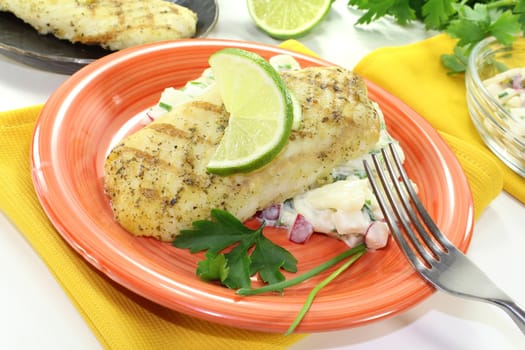 Hake with lemon slice, parsley, chives and potato salad