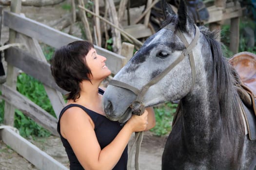 Portrait happy smiling woman with grey horse