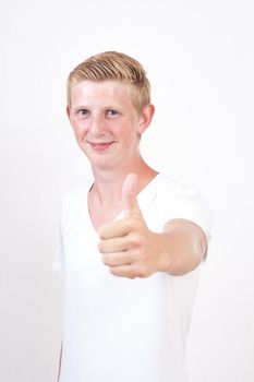 young man with blue eyes gives the thumbs up gesture on grey background