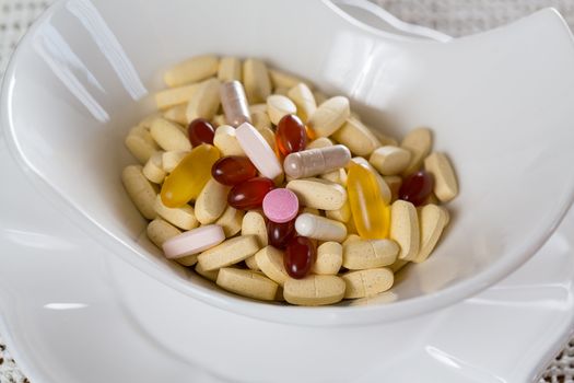 Vitamins in bowl of tablets for breakfast in kitchen