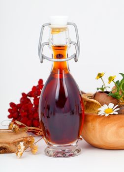 mixture / syrup with rowan berries and herb, on white background.