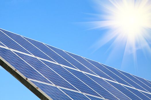 Solar panel against blue sky with sun