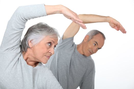 Senior couple stretching in the gym