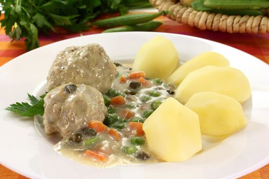 cooked meatballs with capers, peas and carrots