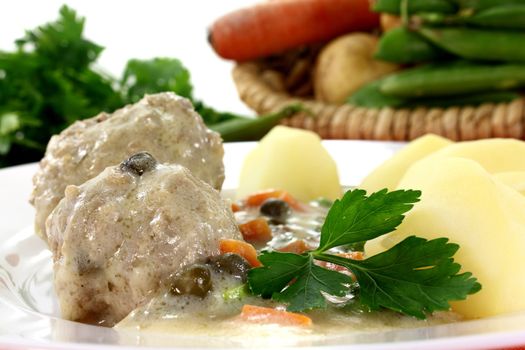 cooked meatballs with capers, peas and carrots