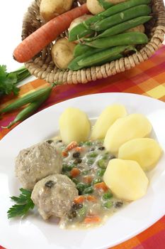 cooked meatballs with capers, peas and carrots