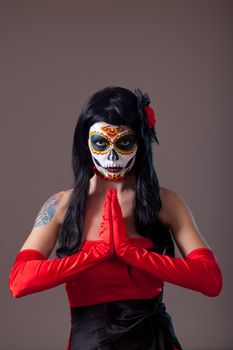 Praying woman with sugar skull make-up, the Day of the Dead 