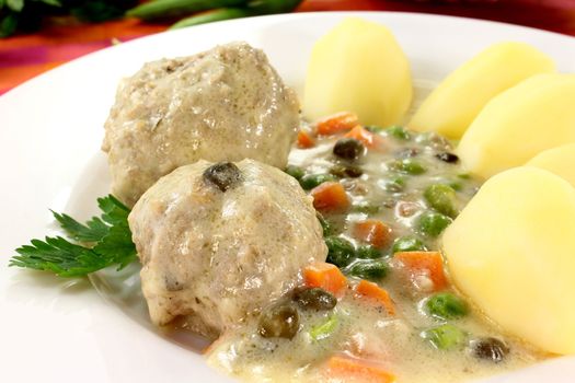 cooked meatballs with capers, peas and carrots