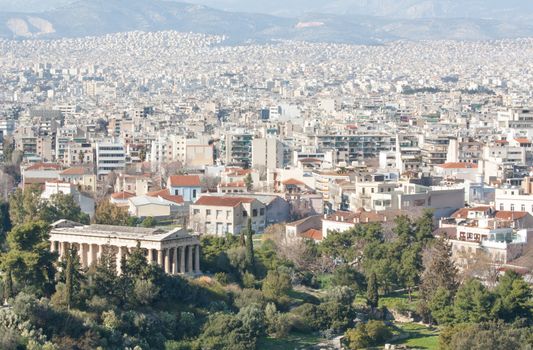 View of the city of Athens as seen from Areopagus or Mars Hill with the temple of Hephaistos (also known as Thissio or Theseion) on the foreground and mountains on the background, Greece.