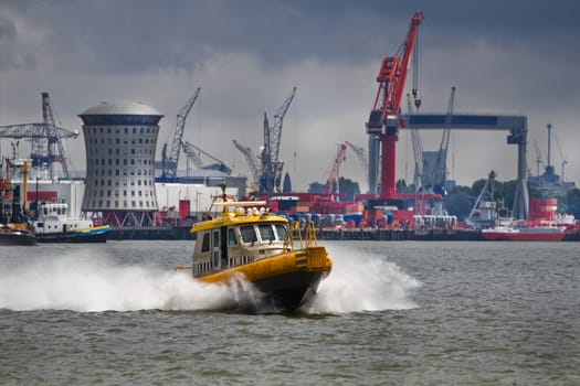 Crewtender on the river with industrial background and upcoming rainstorm