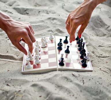 Image of human hands with chess figure making move
