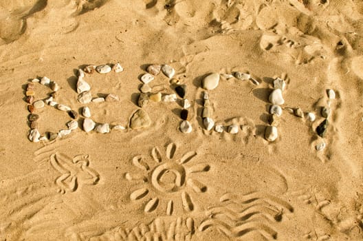 Word BEACH made of stones on the sand.