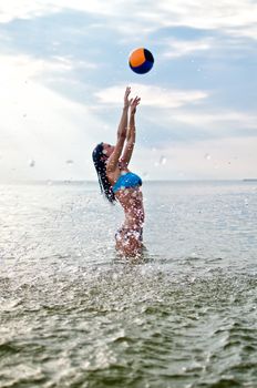 Young woman playing volleyball in the sea