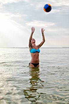 Young woman playing volleyball in the sea