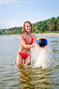 Young woman playing volleyball in the sea