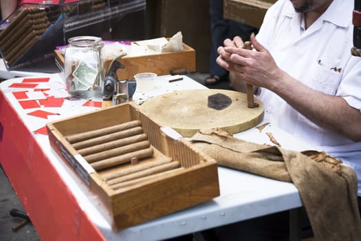 Man hand rolling cigars on the street